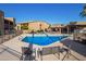 Community pool area with lounge chairs, umbrellas, and desert landscaping in the background at 1730 W Emelita Ave # 2027, Mesa, AZ 85202