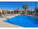 Community pool with clear blue water and lounge chairs with umbrellas at 1730 W Emelita Ave # 2027, Mesa, AZ 85202