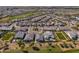 A sprawling aerial view of the neighborhood showcases lush green spaces, mature trees, and private swimming pools at 17362 W Wildwood St, Surprise, AZ 85388