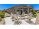 Inviting backyard with a cozy fire pit surrounded by rocking chairs and an outdoor kitchen area at 17362 W Wildwood St, Surprise, AZ 85388