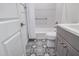 Bathroom featuring a gray vanity, black and white floor tiles, and a shower with grab bars at 17362 W Wildwood St, Surprise, AZ 85388