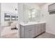 Elegant bathroom featuring double sinks, a large mirror, and views into the main bedroom at 17362 W Wildwood St, Surprise, AZ 85388