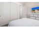 Bright bedroom featuring white walls, white carpet, and a TV mounted to the wall at 17362 W Wildwood St, Surprise, AZ 85388