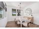 Elegant dining room with a contemporary chandelier, large windows, and a tastefully decorated table setting at 17362 W Wildwood St, Surprise, AZ 85388
