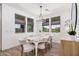 Bright dining room featuring a modern chandelier, large windows with backyard views, and a stylish table at 17362 W Wildwood St, Surprise, AZ 85388