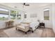 Serene main bedroom boasts natural light, a ceiling fan, and a cozy seating area for relaxation at 17362 W Wildwood St, Surprise, AZ 85388