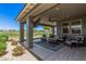 A covered patio with outdoor seating, a ceiling fan, and a view of the golf course at 17362 W Wildwood St, Surprise, AZ 85388