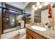 Bathroom features a granite countertop, dark wood cabinets, and a tiled shower with glass doors, offering a modern and sleek design at 17415 N 57Th Ave, Glendale, AZ 85308