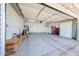 Spacious garage with epoxy flooring, featuring ample storage with cabinets, and plenty of room for parking and projects at 17415 N 57Th Ave, Glendale, AZ 85308