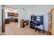 A home office area with dark wooden desks and shelves sits adjacent to a kitchen with stainless steel appliances and wood cabinets at 17415 N 57Th Ave, Glendale, AZ 85308