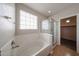 Bathroom showcases a large soaking tub, glass enclosed shower, and tiled floors at 17681 W Molly Ln, Surprise, AZ 85387