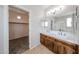 Bathroom featuring double sinks, vanity, walk-in closet, and tiled flooring at 17681 W Molly Ln, Surprise, AZ 85387