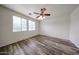 Bedroom with neutral walls, wood-look flooring, and a ceiling fan at 17681 W Molly Ln, Surprise, AZ 85387