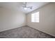 Bedroom features neutral walls, carpet and a white ceiling fan that is well-lit at 17681 W Molly Ln, Surprise, AZ 85387