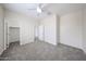 A cozy bedroom features neutral walls, soft gray carpeting, and a ceiling fan for added comfort at 17681 W Molly Ln, Surprise, AZ 85387
