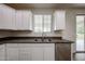 The kitchen has white cabinets, stainless steel appliances, granite countertops and wood-look flooring at 17681 W Molly Ln, Surprise, AZ 85387
