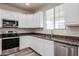 Bright kitchen showcases white cabinets, granite countertops and stainless steel appliances at 17681 W Molly Ln, Surprise, AZ 85387
