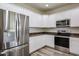 Modern kitchen with stainless steel appliances, granite counters, and white cabinetry at 17681 W Molly Ln, Surprise, AZ 85387