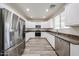Well-lit kitchen featuring stainless steel appliances, granite countertops, and modern cabinets at 17681 W Molly Ln, Surprise, AZ 85387