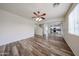 Open living room featuring wood-look floors, a ceiling fan, and natural light at 17681 W Molly Ln, Surprise, AZ 85387