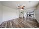 Open living room featuring wood-look floors, a ceiling fan, and natural light at 17681 W Molly Ln, Surprise, AZ 85387