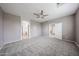 Spacious main bedroom featuring neutral paint, ceiling fan, and plush carpeting at 17681 W Molly Ln, Surprise, AZ 85387