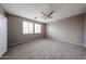 Bright main bedroom featuring neutral paint, ceiling fan, and plush carpeting at 17681 W Molly Ln, Surprise, AZ 85387