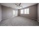 Large main bedroom illuminated with natural light, ceiling fan, and plush carpeting at 17681 W Molly Ln, Surprise, AZ 85387