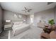 Serene bedroom features neutral tones, plush bedding, ceiling fan, and stylish decor for relaxation at 17681 W Molly Ln, Surprise, AZ 85387