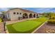 Backyard featuring a covered patio, putting green, and well-manicured landscaping at 18226 W Marshall Ct, Litchfield Park, AZ 85340