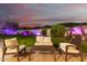 Backyard patio with outdoor seating area, adjacent to manicured lawn and illuminated waterfall at 18226 W Marshall Ct, Litchfield Park, AZ 85340