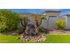Backyard landscape with a stone waterfall, lush plants, and well-manicured landscaping at 18226 W Marshall Ct, Litchfield Park, AZ 85340