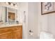 A powder bathroom featuring wood cabinets, granite countertops, and decorative accents at 18226 W Marshall Ct, Litchfield Park, AZ 85340