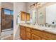 Bathroom featuring double sinks with granite countertops and a stone-walled shower at 18226 W Marshall Ct, Litchfield Park, AZ 85340