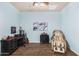 A bedroom featuring wood floors, a desk, massage chair and natural lighting at 18226 W Marshall Ct, Litchfield Park, AZ 85340