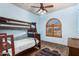 Charming blue bedroom features a wooden bunk bed and a arched window with wood shutters at 18226 W Marshall Ct, Litchfield Park, AZ 85340