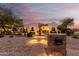Elegant home featuring a decorative fountain, desert landscaping, and soft lighting accents at 18226 W Marshall Ct, Litchfield Park, AZ 85340