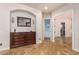 Hallway with dark wood dresser, neutral walls, decorative mirror, and access to other rooms at 18226 W Marshall Ct, Litchfield Park, AZ 85340