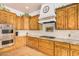 A kitchen featuring wood cabinets, stainless steel appliances and a decorative range hood at 18226 W Marshall Ct, Litchfield Park, AZ 85340