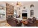 Comfortable living area with stone fireplace, TV niche, recessed lighting, and leather seating at 18226 W Marshall Ct, Litchfield Park, AZ 85340