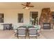 Covered patio with an outdoor kitchen, a fireplace, ceiling fan and a dining table with comfortable seating at 18226 W Marshall Ct, Litchfield Park, AZ 85340