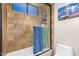Elegant shower featuring travertine tile and glass enclosure, enhancing a luxurious bathing experience at 18226 W Marshall Ct, Litchfield Park, AZ 85340