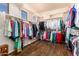 A large walk-in closet with custom shelving and wooden floors at 18226 W Marshall Ct, Litchfield Park, AZ 85340