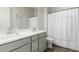 Clean bathroom featuring gray cabinets, double sinks, and white shower curtain at 1829 N 43Rd Ter, Phoenix, AZ 85008