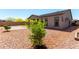 Low maintenance gravel backyard featuring lush green trees and grass at 18508 W Galveston St, Goodyear, AZ 85338