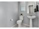Powder room featuring modern fixtures, a pedestal sink, and a low-flow toilet at 18508 W Galveston St, Goodyear, AZ 85338