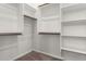 A spacious walk-in closet featuring ample shelving and wooden rods for optimal storage solutions at 18508 W Galveston St, Goodyear, AZ 85338
