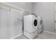 Modern laundry room with neutral walls, tile flooring, modern washer and dryer and shelving at 18508 W Galveston St, Goodyear, AZ 85338