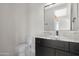 Elegant bathroom showcasing black vanity with granite countertop, a toilet, and a sleek mirror at 19622 W Pasadena Ave, Litchfield Park, AZ 85340