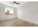 Bedroom featuring light wood floors, a ceiling fan, and a large window at 19622 W Pasadena Ave, Litchfield Park, AZ 85340